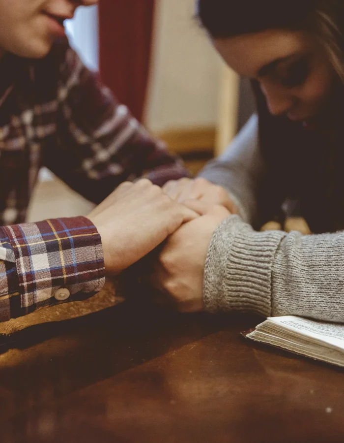 closeup-couple-holding-hands-table